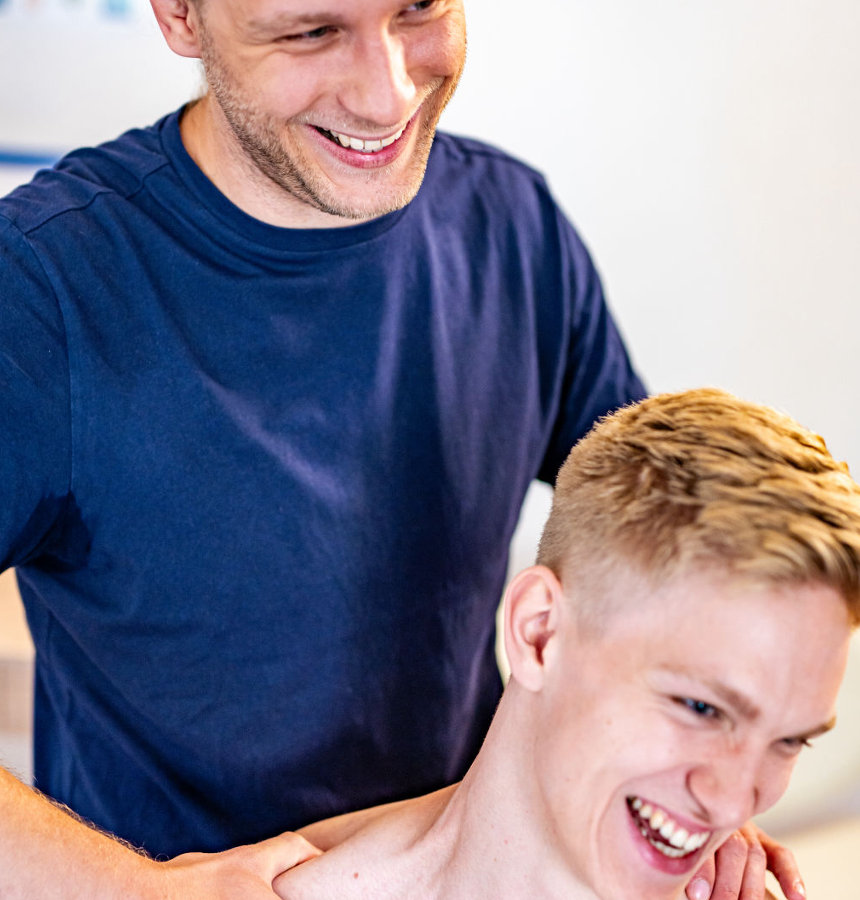 Oliver Diller drückt bei seinem Patienten einen Triggerpunkt im Nacken-/Schulterbereich